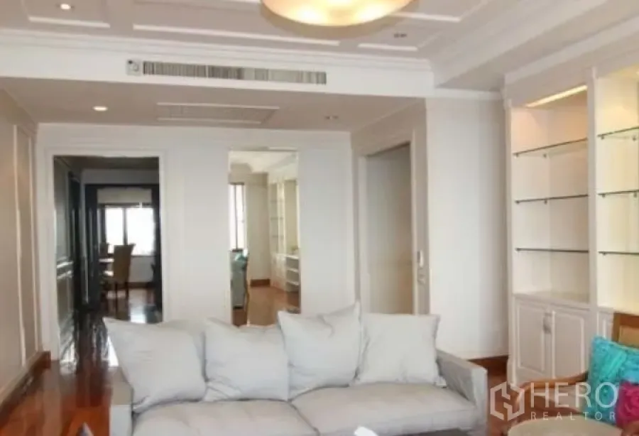 公寓 出租在Sathon, Bangkok - 客厅明亮，吊顶与内置展示柜相配，沙发面向走廊，位于沙吞公寓内。