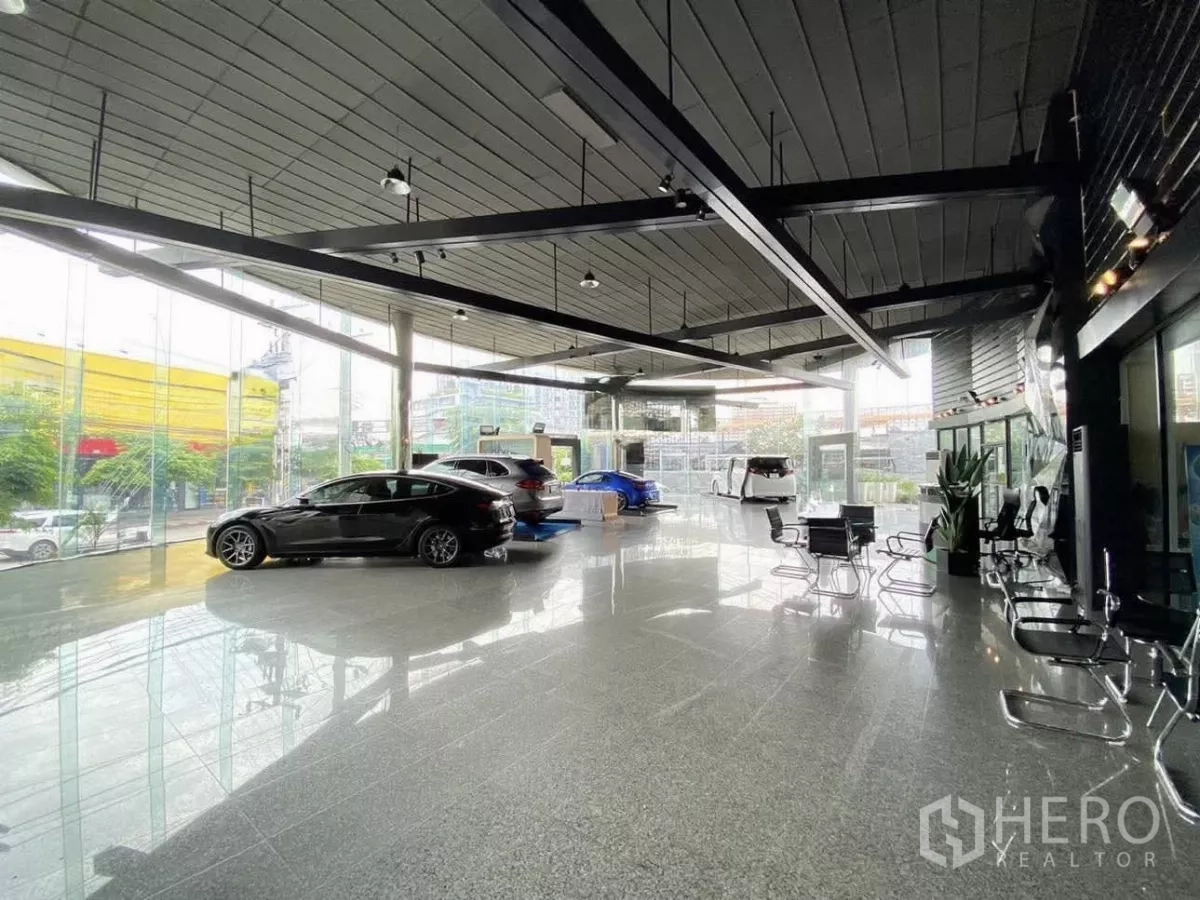 零售空间 出租在Wang Thonglang, Bangkok - 展厅内部宽敞，落地玻璃与亮面地坪，陈列车辆与等候座位