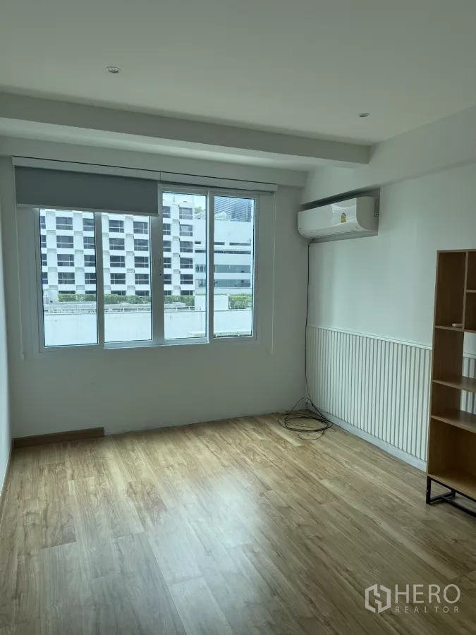 Shophouse for rent - Top-floor room with large window, wood-look floor, and split-type air conditioner.