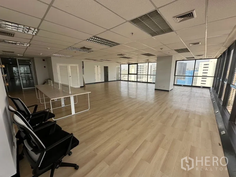 办公空间 出租在Bang Rak, Bangkok - 开放式办公室广角视图，窗边设有办公桌与座椅。