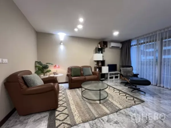 ทาวน์เฮาส์ ให้เช่าหรือขายในSuan Luang, Bangkok - มุมนั่งเล่นโซฟาหนัง พรม และผนังกระจกบานใหญ่พร้อมชั้นวางทีวี