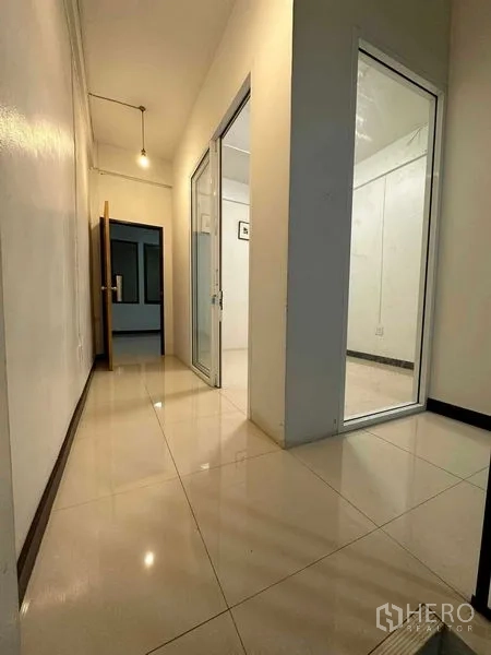 อาคารพาณิชย์ ให้เช่าในChatuchak, Bangkok - โถงทางเดินพื้นเงาพร้อมผนังกระจกบานเลื่อนกั้นห้องทำงาน.