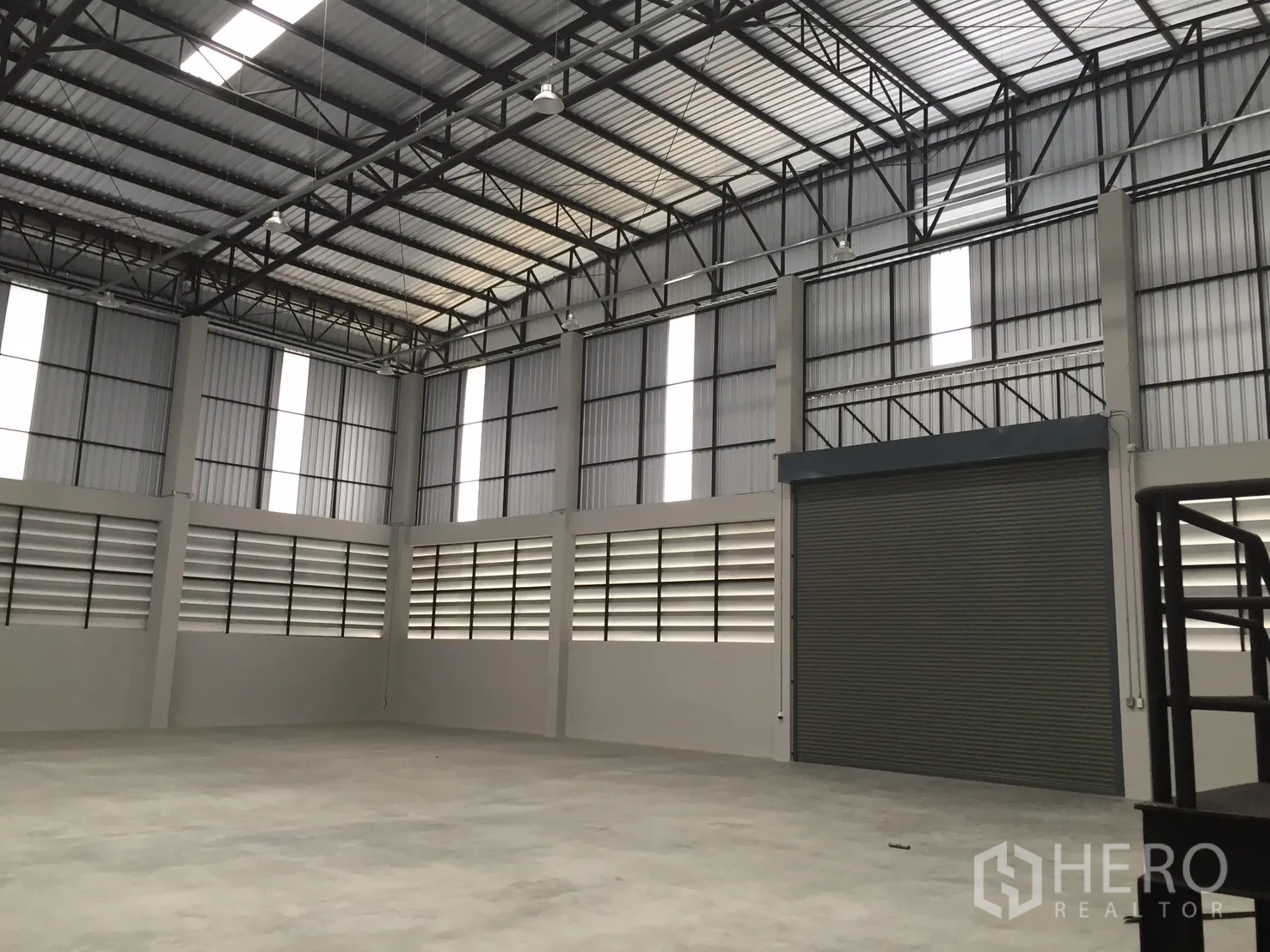 Warehouse for rent in Bang Phli, Samut Prakan - Warehouse interior with a big roller shutter door and steel truss roof.
