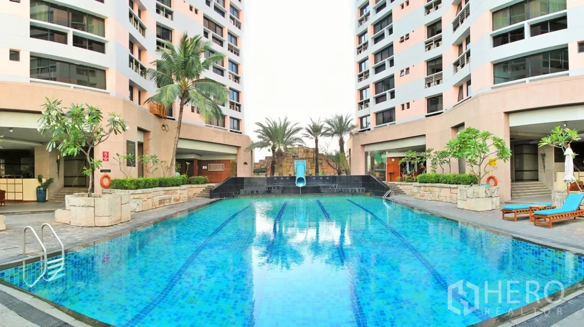 公寓 出租在Khlong Toei, Bangkok - President Park 度假式户外泳池，设泳道与滑梯，棕榈树环绕并邻接住宅楼。