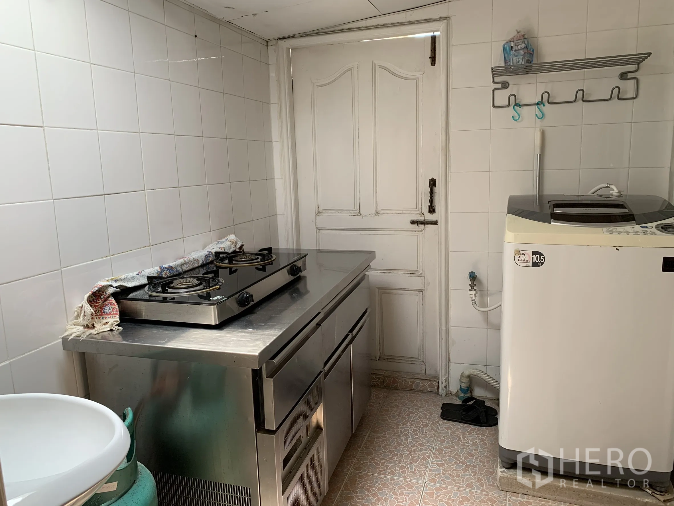 บ้านเดี่ยว for rent in Saphan Sung, Bangkok - ครัวขนาดกะทัดรัด มีเตาแก๊สบนเคาน์เตอร์สแตนเลส ผนังกระเบื้อง และเครื่องซักผ้า.