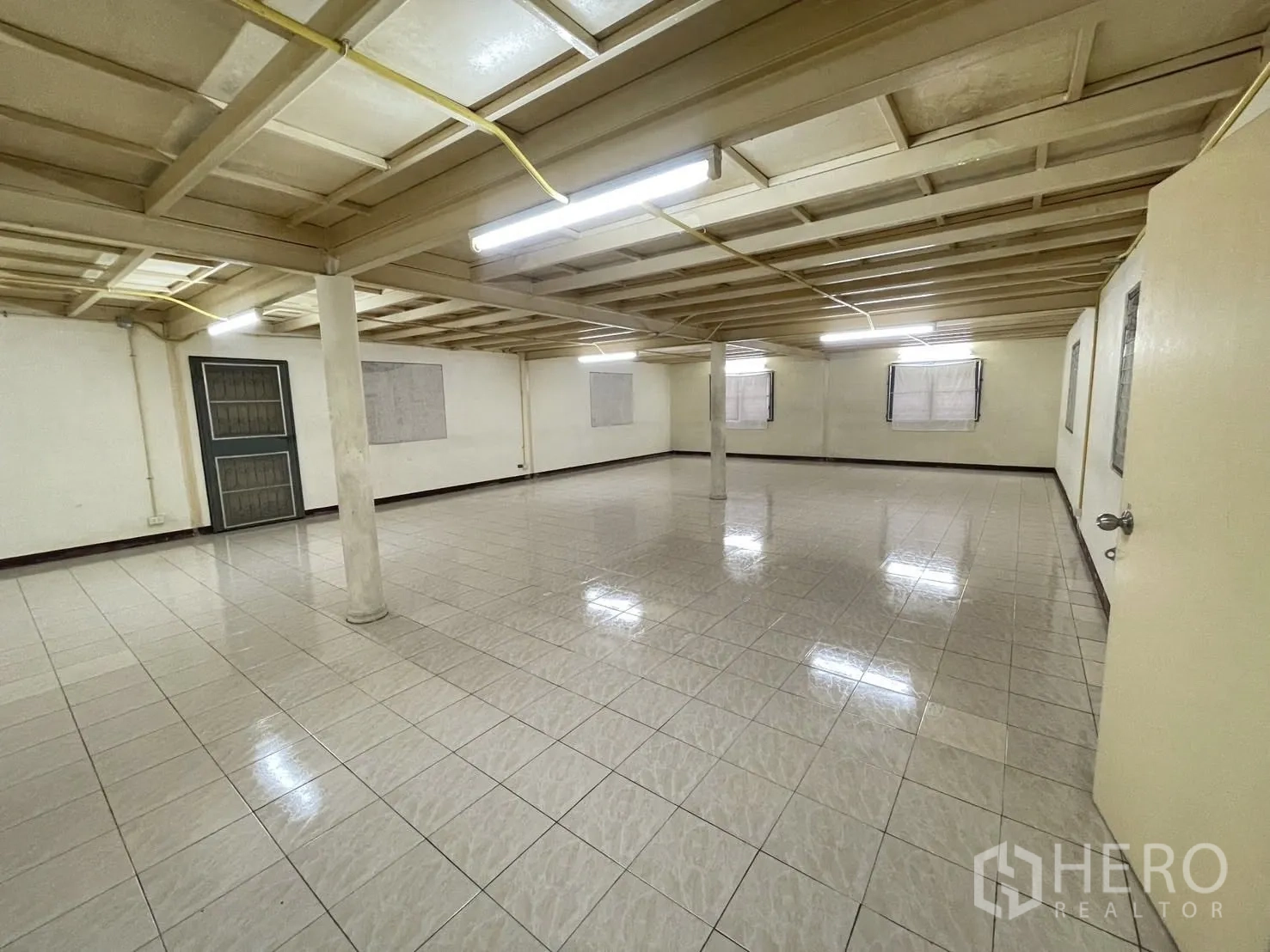 货栈 出租在Lat Phrao, Bangkok - 宽敞开放式瓷砖房，低天花、日光灯与支撑柱。