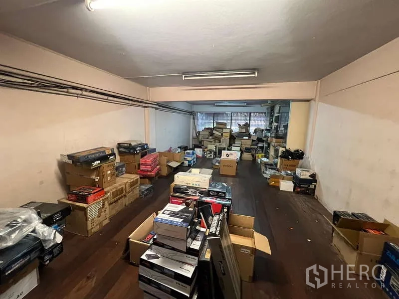 店屋 出租 - 大型储物间，堆满纸箱与货架，顶置日光灯。