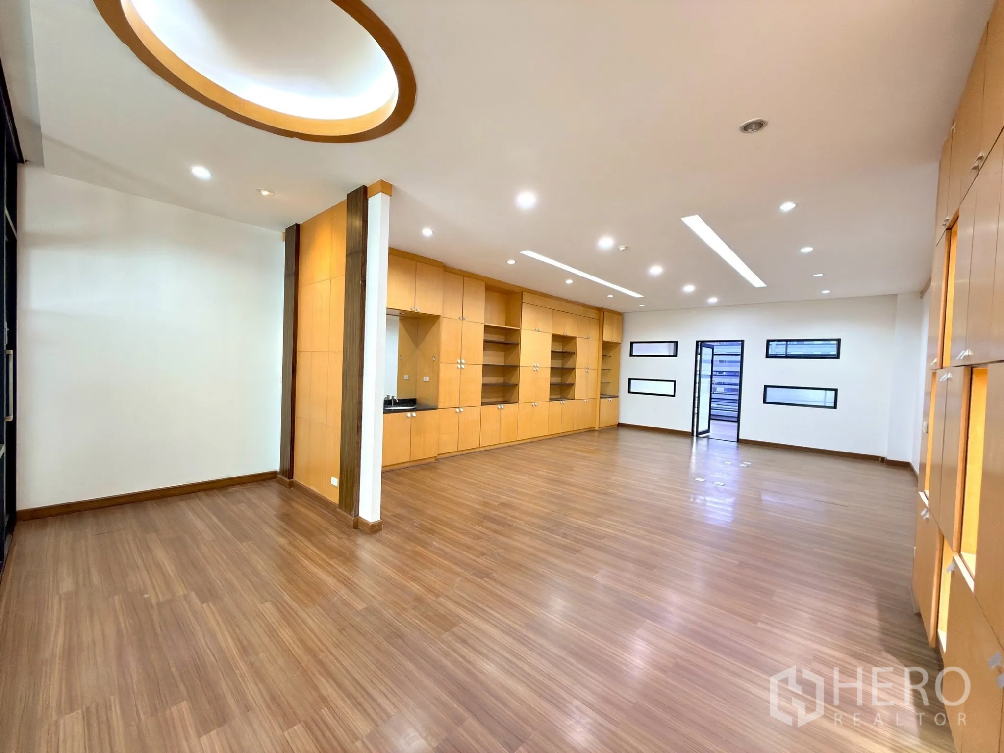 Office Space for rent in Watthana, Bangkok - Spacious workspace with small horizontal windows and long runs of built-in storage.
