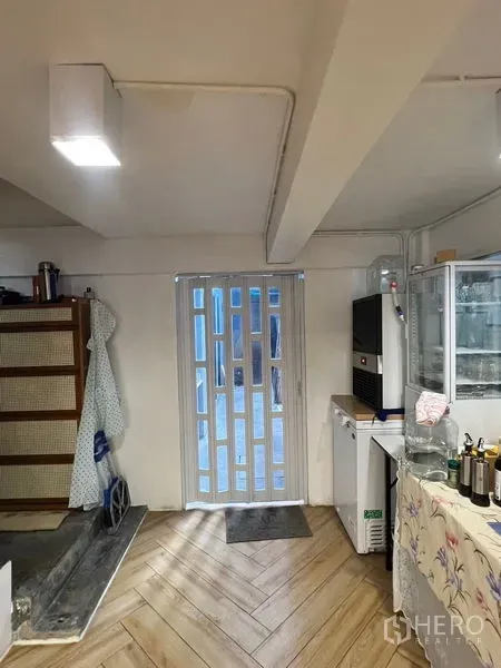 อาคารพาณิชย์ ให้เช่าในPhra Khanong, Bangkok - โซนเตรียมอาหารชั้นล่าง ประตูบานเลื่อน ตู้แช่ และพื้นไม้ลายก้างปลา.