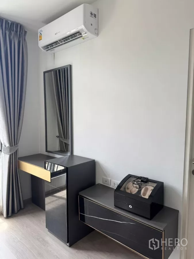 Townhouse for rent in Bang Phli, Samut Prakan - Bedroom corner with dressing table, storage cabinet, and wall-mounted air conditioner.