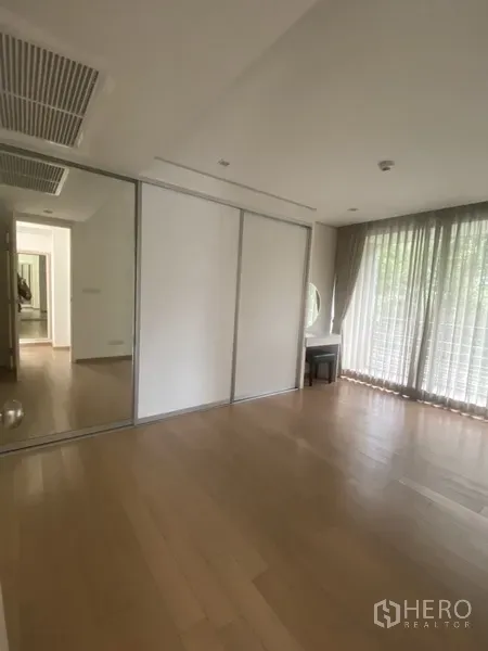 คอนโด ให้เช่าในPathum Wan, Bangkok - ห้องนอนพร้อมตู้เสื้อผ้าบานเลื่อนกระจก โต๊ะเครื่องแป้ง ม่านโปร่ง และพื้นไม้