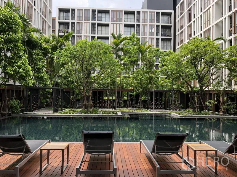 คอนโด ให้เช่าในWatthana, Bangkok - สระว่ายน้ำสไตล์รีสอร์ทกลางคอร์ทยาร์ด รายล้อมด้วยต้นไม้และเตียงอาบแดดบนดาดไม้