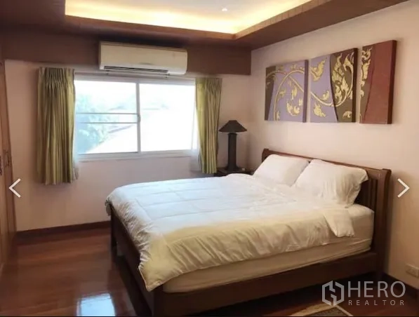 Detached House for sale in Saphan Sung, Bangkok - Master bedroom with wood flooring, recessed ceiling lights, large window and air conditioning.