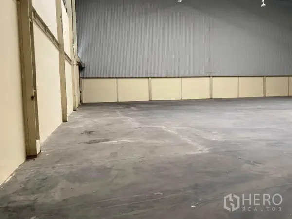 Factory for rent in Bang Phli, Samut Prakan - Open factory hall with concrete floor and high metal cladding walls.