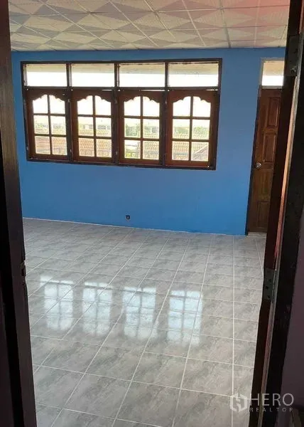 Warehouse for rent in Sai Noi, Nonthaburi - Bright office room with tiled floor, blue wall, and wooden-framed windows.