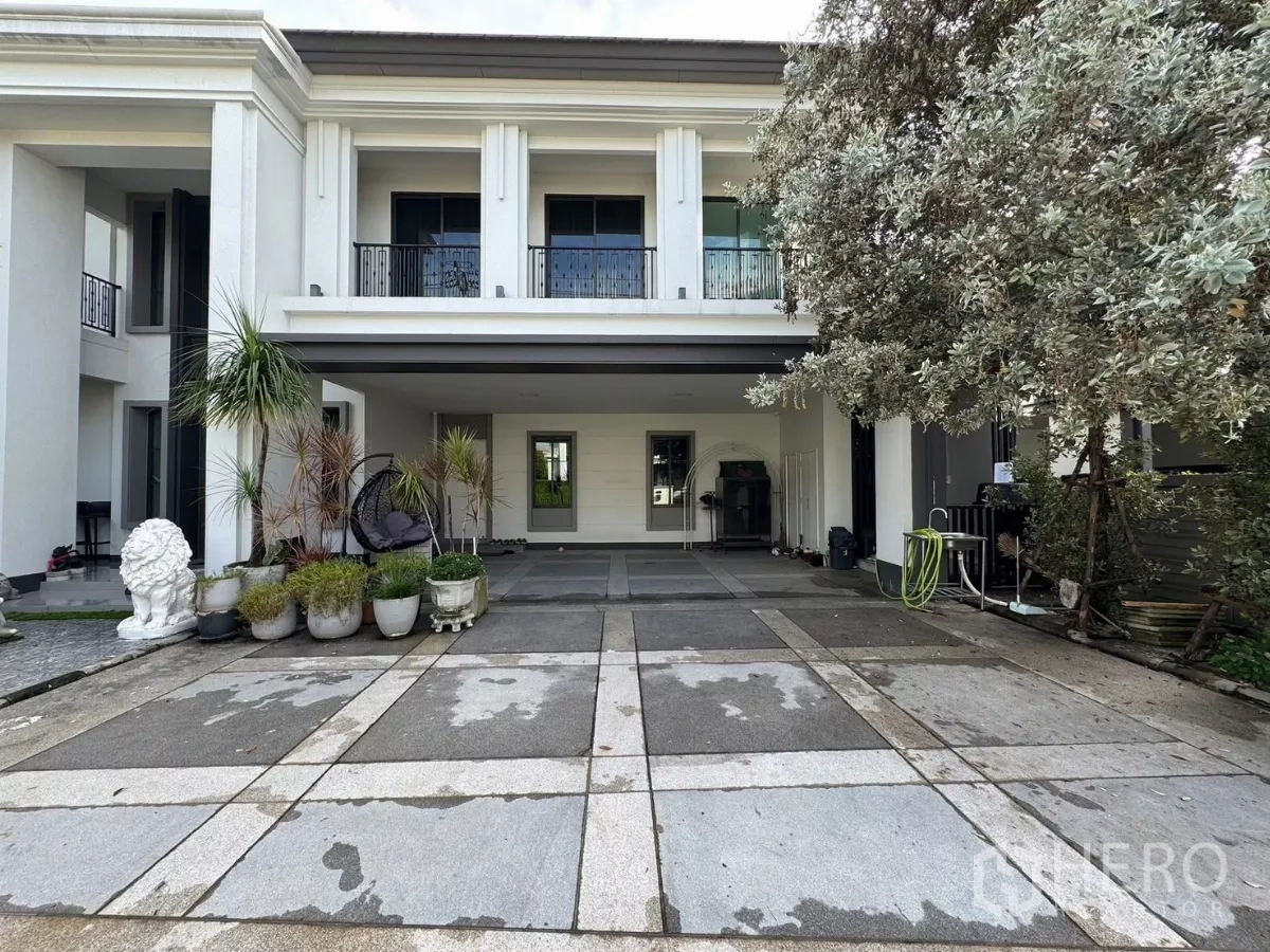 独立式住宅 出售在Mueang Pathum Thani, Pathum Thani - 带顶车棚与入口，摆放绿植和大树。