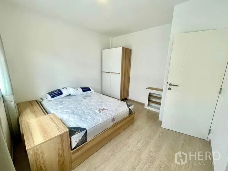 ทาวน์เฮาส์ ให้เช่าในPrawet, Bangkok - ห้องนอนที่สองพร้อมเตียง ตู้เสื้อผ้า และพื้นลายไม้โทนอ่อน