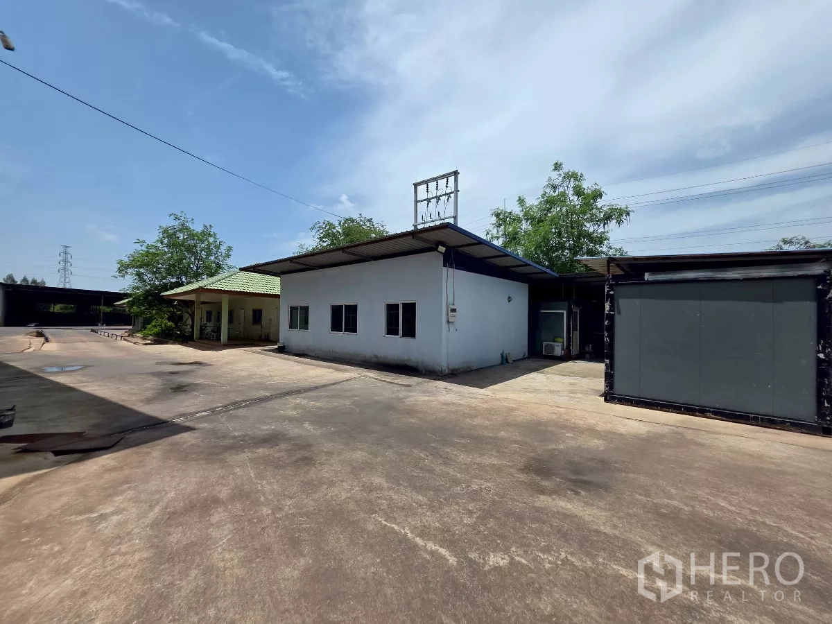 Factory for rent in Mueang Samut Sakhon, Samut Sakhon - Service buildings and covered shelters surrounding a large paved circulation yard.