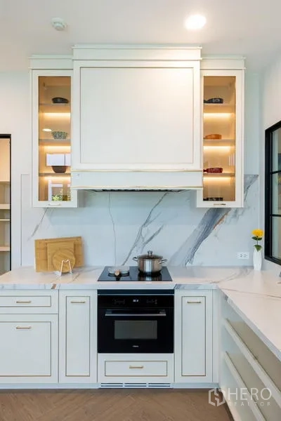 Detached House for sale in Saphan Sung, Bangkok - Cooking zone with induction hob, oven and illuminated display shelves.