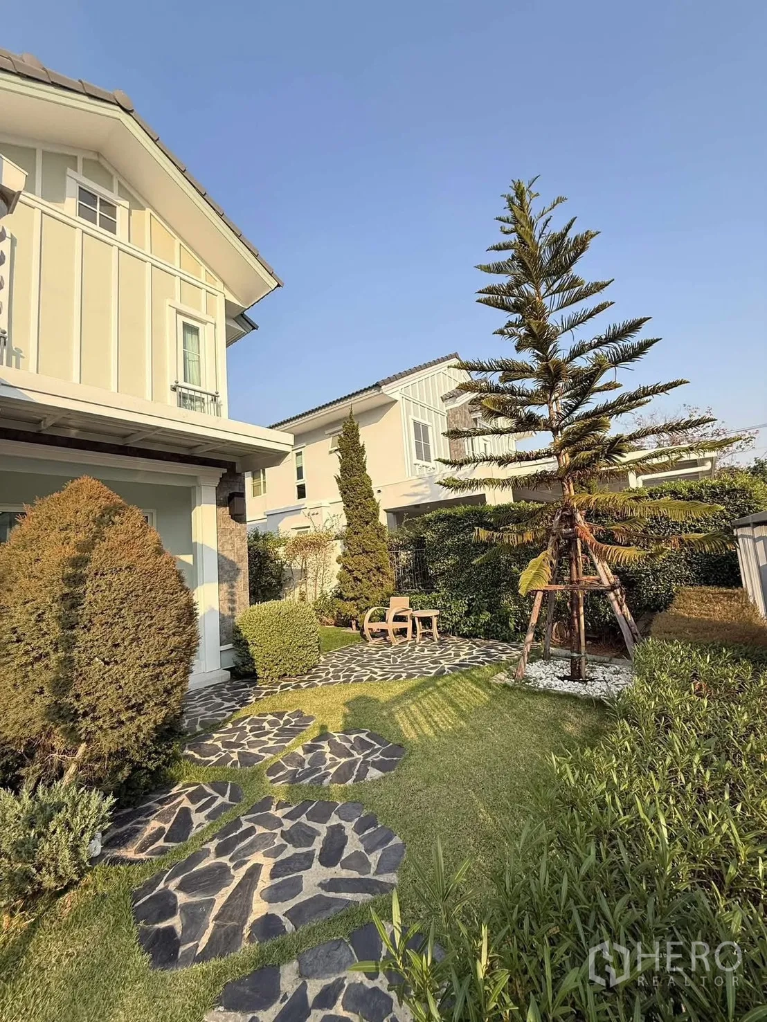 Detached House for rent in Bang Phli, Samut Prakan - Landscaped garden with stone path, lawn and tall tree beside the house facade.