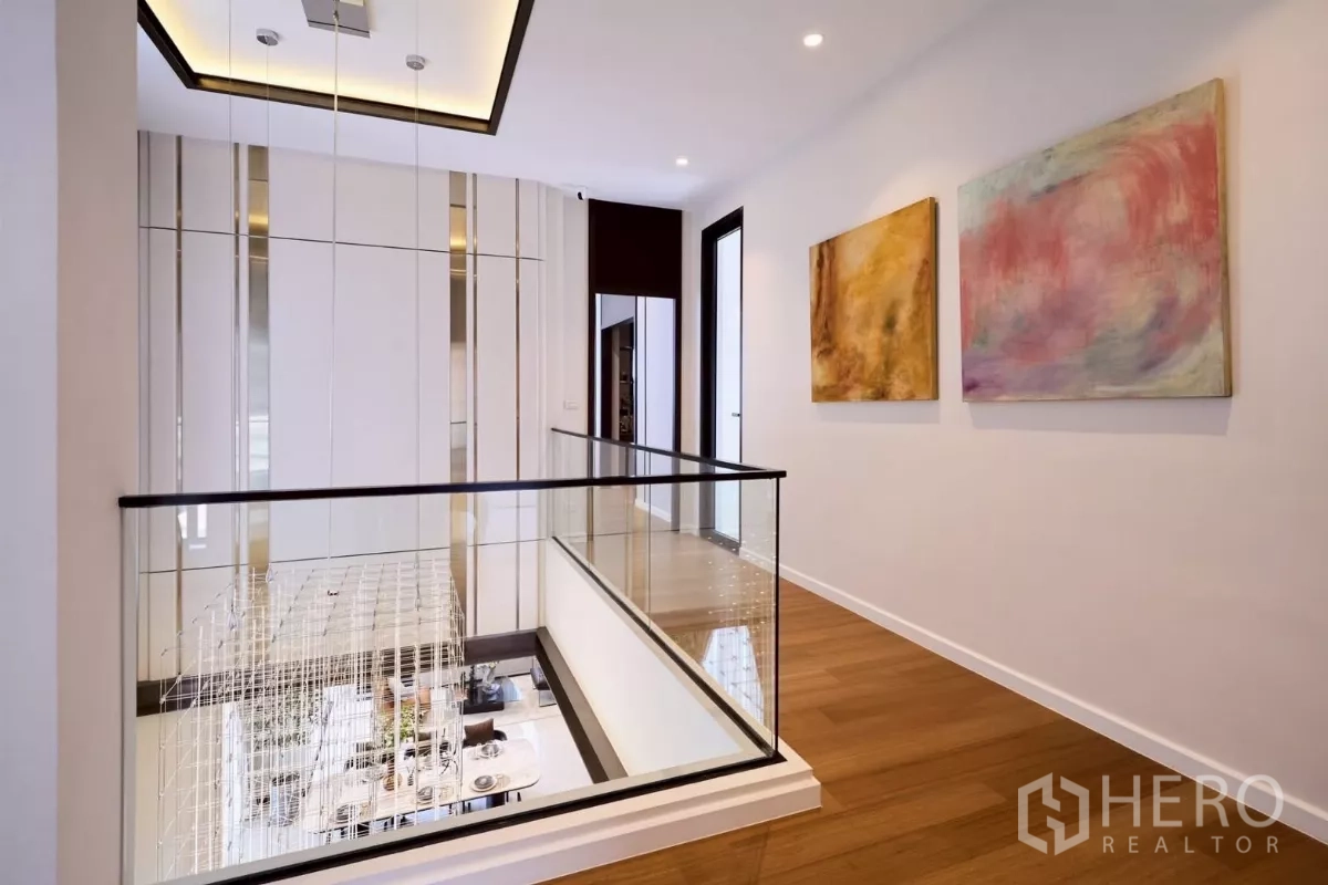 บ้าน ขายในLat Phrao, Bangkok - โถงชั้นบน ราวกันตกกระจก มองลงเห็นโคมระย้าและพื้นที่นั่งเล่นด้านล่าง