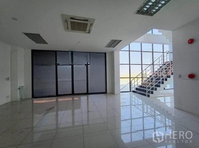 货栈 出租或出售在Pathum Thani - 采光充足的大堂，瓷砖地面与玻璃楼梯。