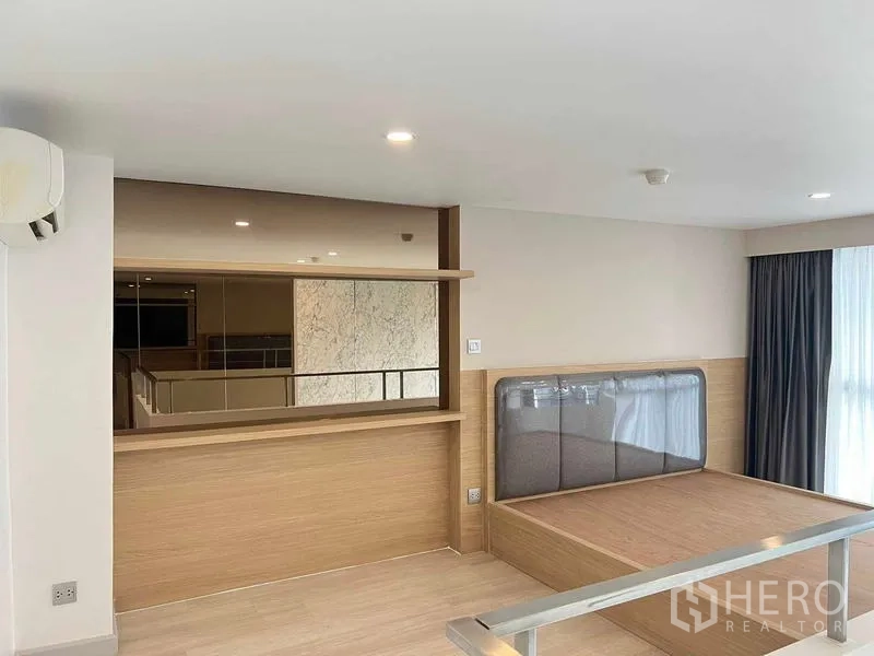 คอนโด ขายในSathon, Bangkok - ห้องนอนชั้นลอย เตียงยกพื้น โทนไม้ และผ้าม่านสูง