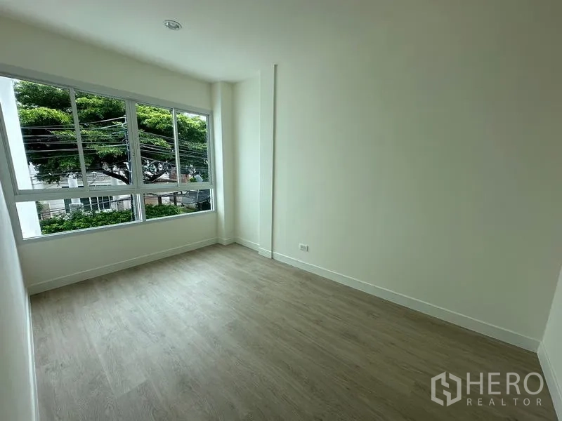 Home Office for rent in Khlong Toei, Bangkok - Bright corner room with oversized windows overlooking leafy trees.