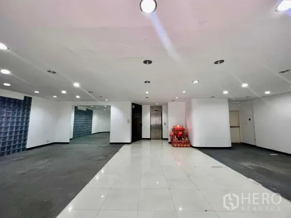 Shophouse for rent in Khlong San, Bangkok - Lobby with elevator, downlights, tiled flooring and a glass-block accent wall.