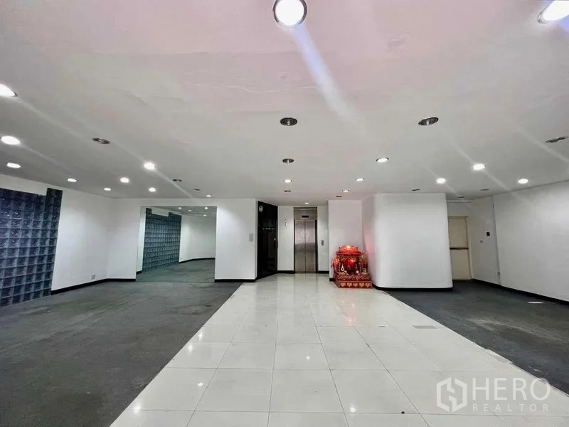 Shophouse for rent in Khlong San, Bangkok - Lobby with elevator, downlights, tiled flooring and a glass-block accent wall.