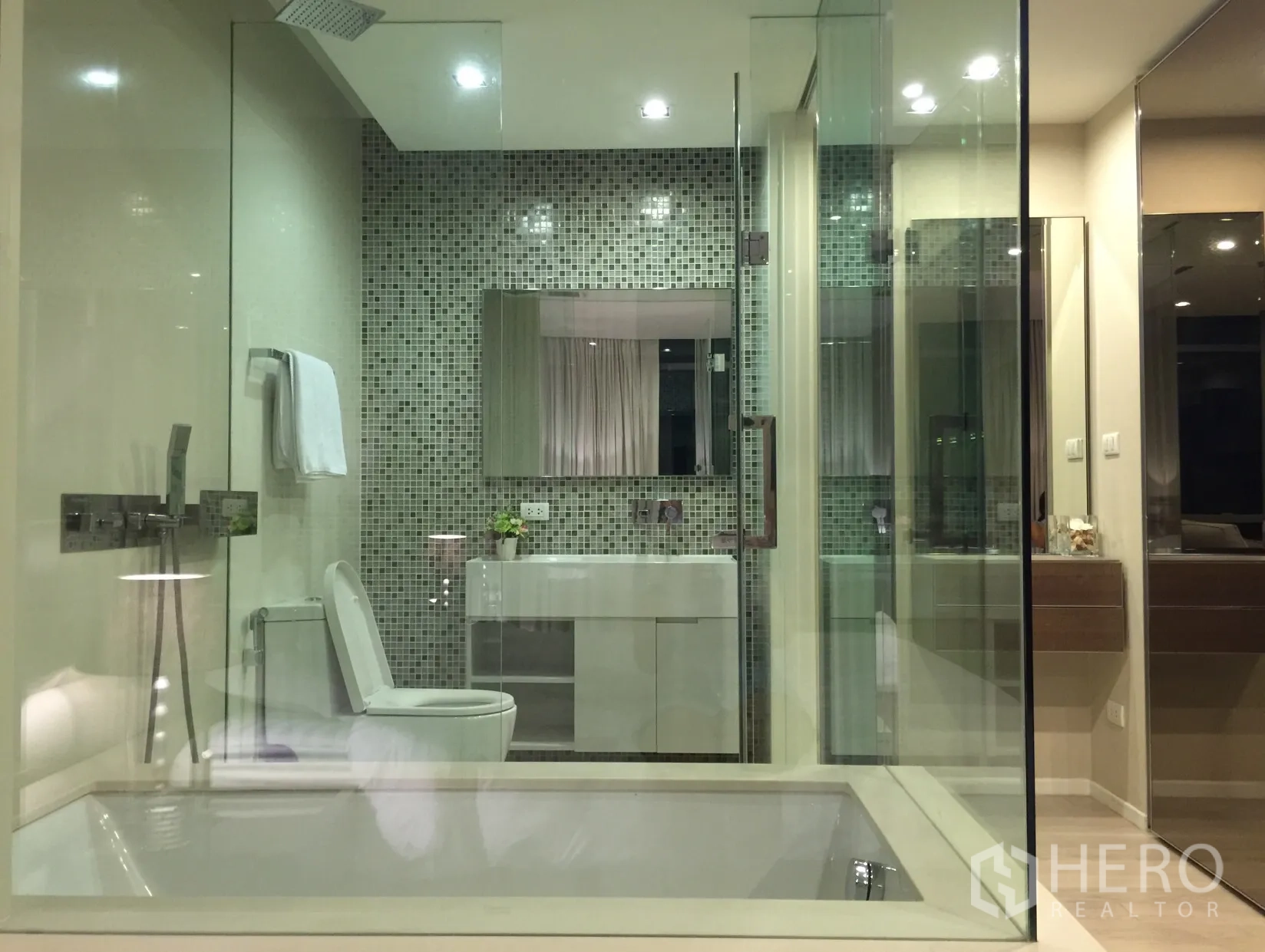 Condominium for rent or sale in Watthana, Bangkok - Modern bathroom with glass shower, bathtub, mosaic feature wall and sleek vanity.