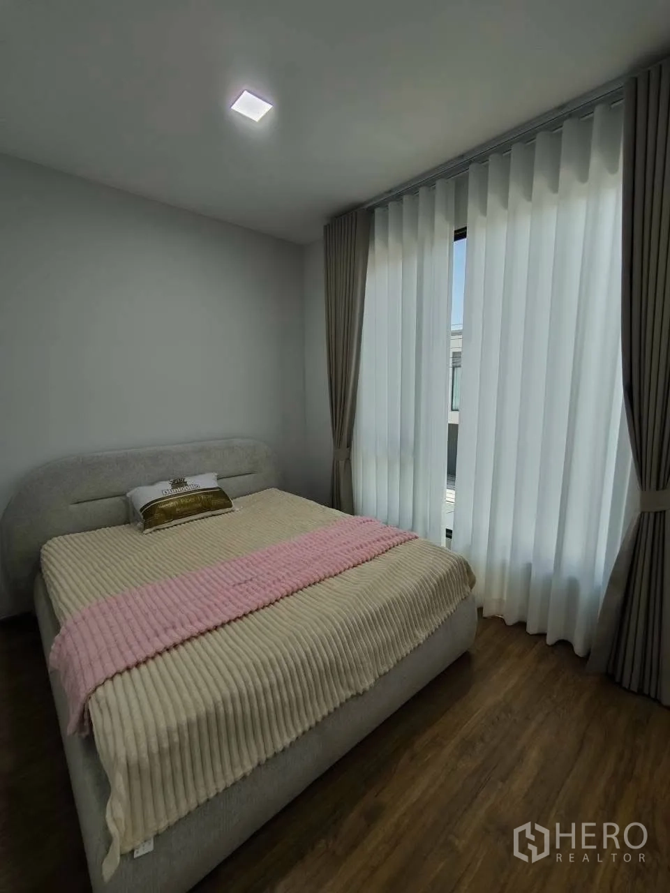 ทาวน์เฮาส์ for rent in Bang Phli, Samut Prakan - ห้องนอนเตียงใหญ่ พื้นไม้ และหน้าต่างพร้อมม่านทึบโปร่ง
