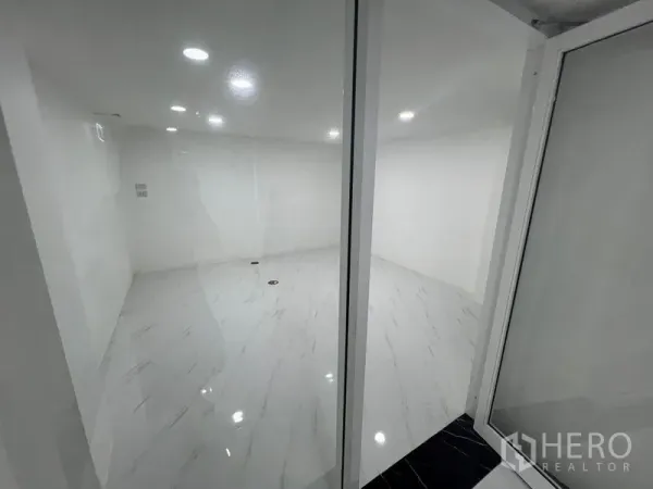Office Space for rent or sale in Wang Thonglang, Bangkok - Glass-partitioned meeting room with white marble-look tile and recessed lighting.