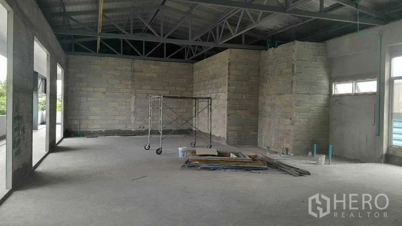 零售空间 出租在Khlong Toei, Bangkok - 二楼开放式零售毛坯空间，挑高金属桁架与未粉刷砖墙，位于Phra Khanong。