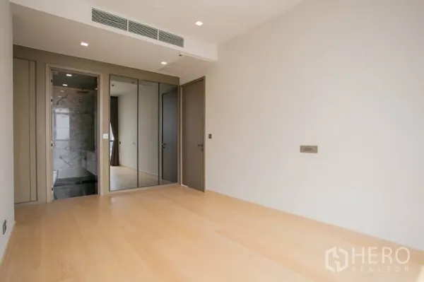 公寓 出租或出售在Watthana, Bangkok - 卧室配浅木地板与镜面衣柜，可直通卫浴。