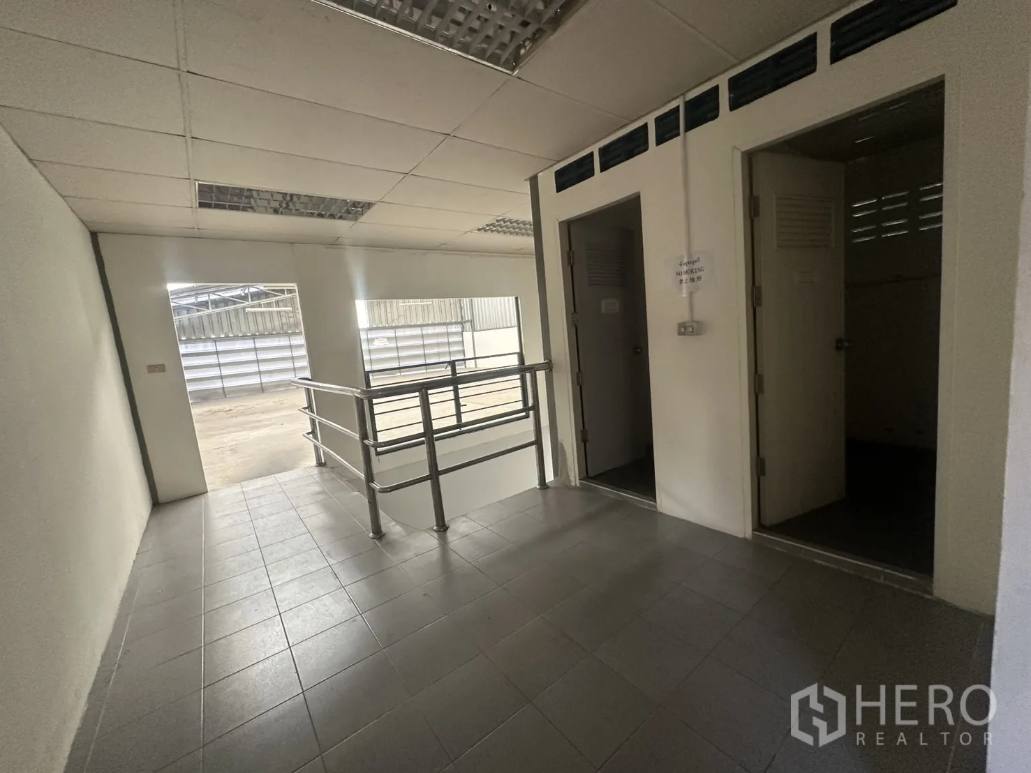 Warehouse for rent in Suan Luang, Bangkok - Landing with two restroom doors and railings beside the mezzanine.
