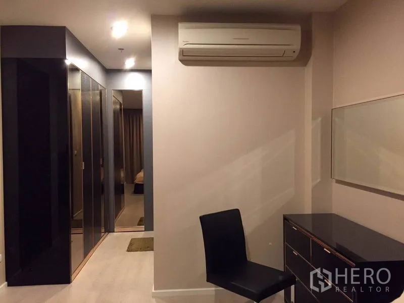 公寓 出租在Sathon, Bangkok - 主卧一角带梳妆台、座椅、空调与亮面衣柜。