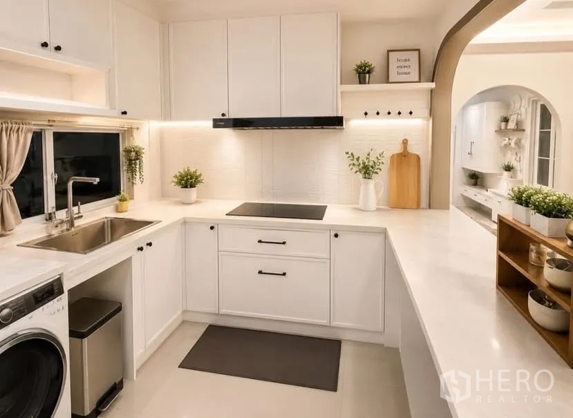 Detached House for rent or sale in Bang Phli, Samut Prakan - Bright white U-shaped kitchen with cooktop, sink, and upper cabinets.