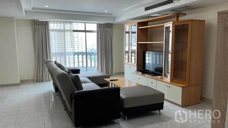 คอนโด ให้เช่าในWatthana, Bangkok - ห้องนั่งเล่นสว่างพร้อมโซฟารูปตัว L ตู้ทีวี ระเบียง และวิวเมืองในคอนโดเขตวัฒนา