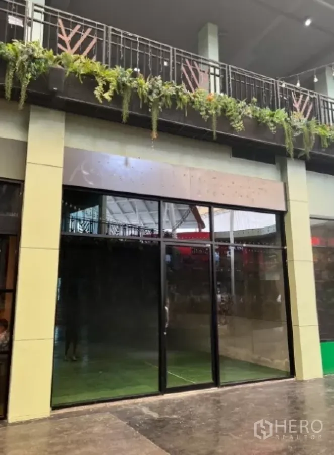 零售空间 出租 - 曼谷 Suan Luang 一层商铺外立面，整面落地玻璃门与有顶走道。