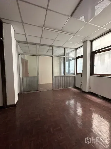 Shophouse for rent in Sathon, Bangkok - Partitioned office area with glass sliding doors and large windows allowing natural light.