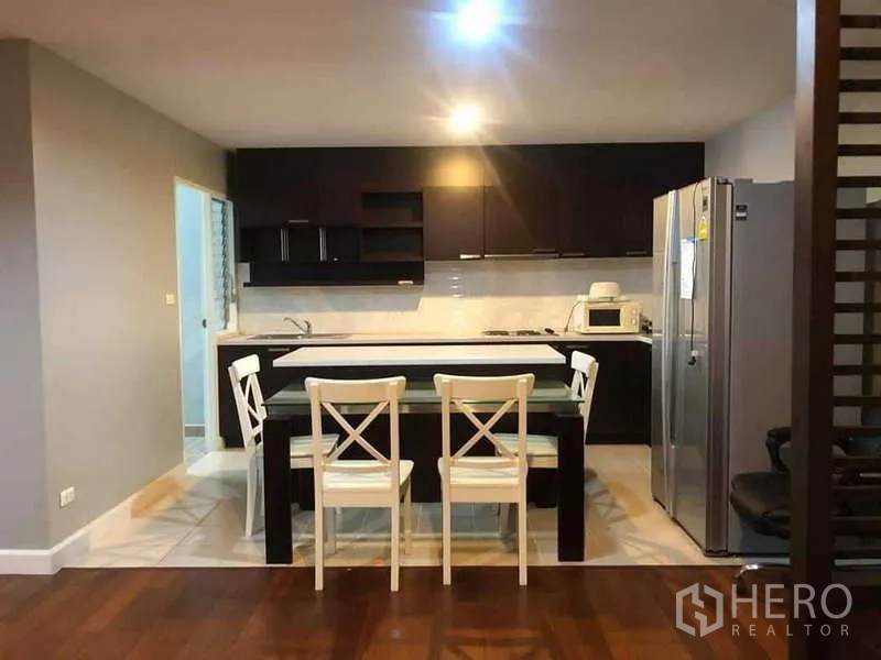 公寓 出售在Yan Nawa, Bangkok - 厨房全景，带早餐中岛和四把白色餐椅。