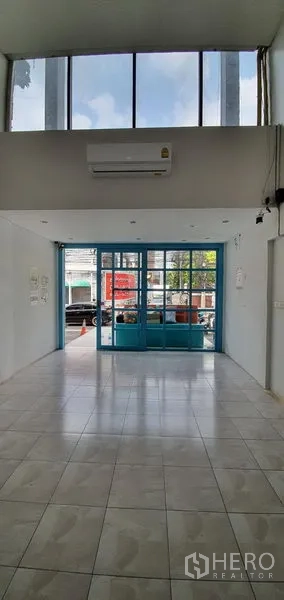 Home Office for rent in Khlong Toei, Bangkok - Bright open lobby with tall windows and tiled floor facing the street.