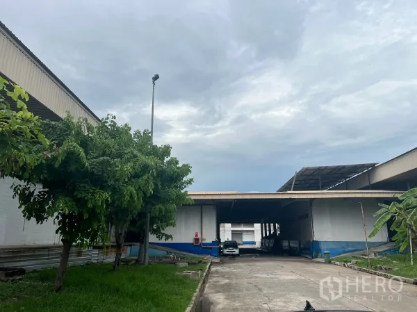 Factory for rent in Bang Pakong, Chachoengsao - Exterior driveway between factory buildings with covered loading bays and parking space.