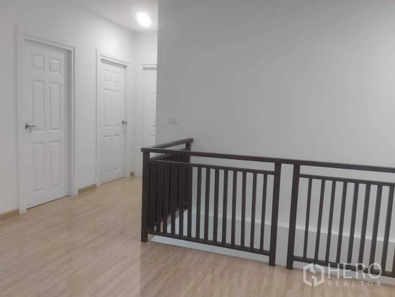 บ้าน ขายในPhra Khanong, Bangkok - โถงบันไดชั้นบน ราวบันไดสีเข้ม และประตูห้องนอนหลายบาน