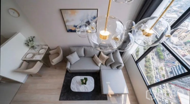 คอนโด ให้เช่าในSathon, Bangkok - มุมมองจากด้านบนของห้องรับแขกสไตล์ลอฟต์ โคมไฟโมเดิร์น โซฟา L และวิวเมืองผ่านกระจกสูง