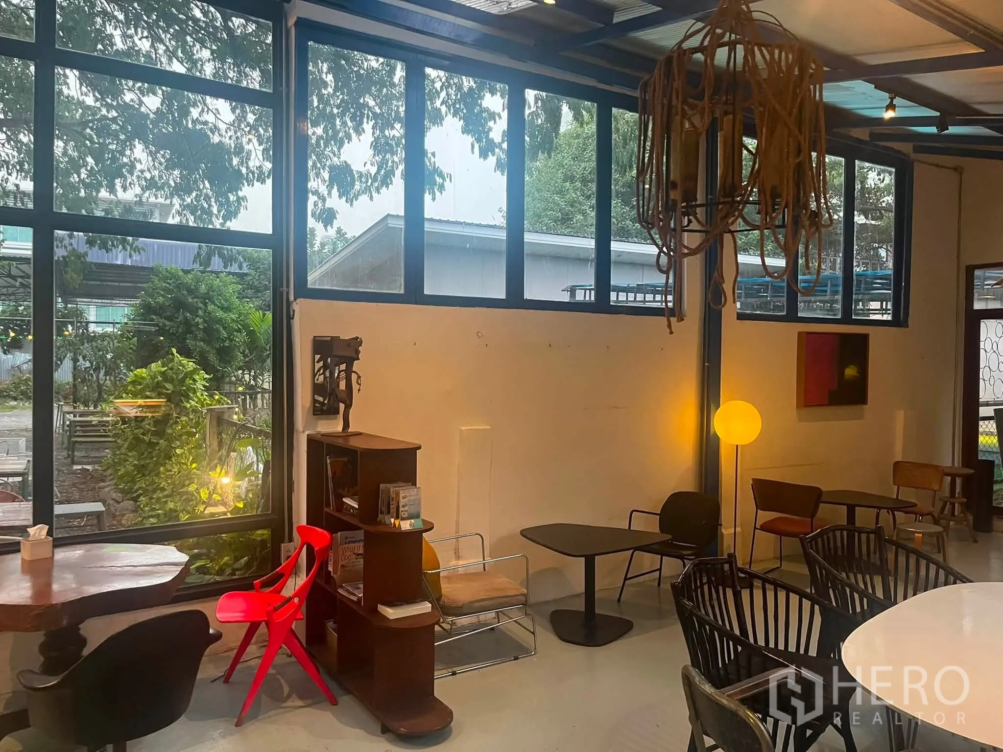 零售空间 for rent in Watthana, Bangkok - 角落空间设大窗、矮桌、球形落地灯与现代座椅。