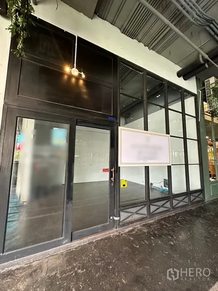 พื้นที่ขายปลีก ให้เช่าในKhlong Toei, Bangkok - หน้าร้านชั้นล่าง กระจกเต็มบานกรอบสีดำ พร้อมประตูกระจกและพื้นที่ติดป้าย