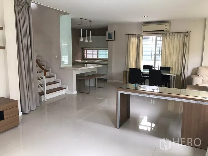 Detached House for rent in Khlong Sam Wa, Bangkok - Open-plan ground floor with glossy tiles, staircase, dining zone and breakfast bar.