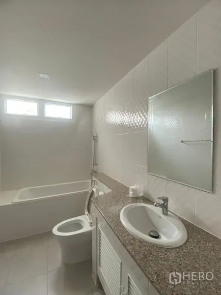 公寓 出租在Sathon, Bangkok - 整洁浴室，配浴缸、花岗岩台面、洗手盆、镜子与高窗采光。